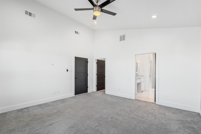 spare room with high vaulted ceiling, light colored carpet, and ceiling fan