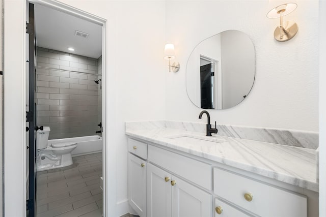 full bathroom with vanity, toilet, tiled shower / bath combo, and tile patterned flooring