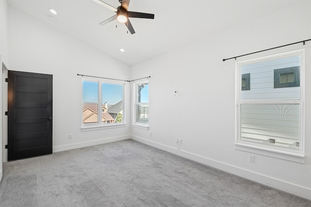 empty room featuring lofted ceiling, light colored carpet, and ceiling fan