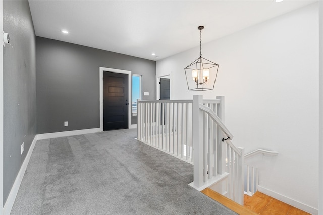 hall featuring a notable chandelier and carpet floors