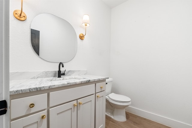 bathroom featuring vanity, hardwood / wood-style floors, and toilet