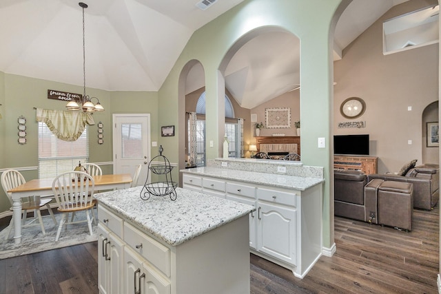 kitchen with pendant lighting, dark wood-type flooring, white cabinets, and a kitchen island