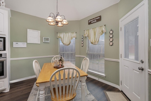 dining room with dark hardwood / wood-style floors and a chandelier