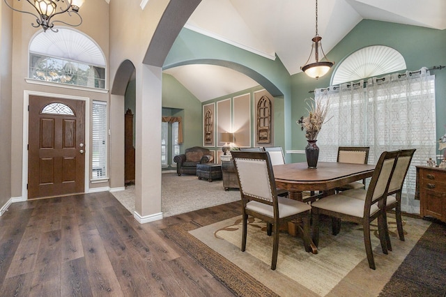 dining room featuring an inviting chandelier, dark wood-type flooring, and high vaulted ceiling