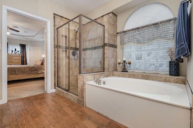 bathroom with hardwood / wood-style flooring, a raised ceiling, independent shower and bath, and ceiling fan