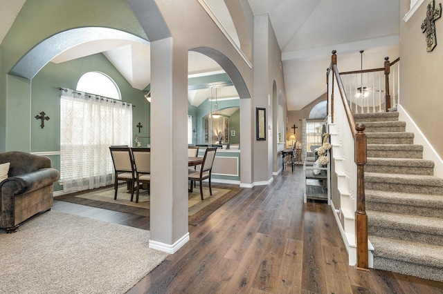 foyer entrance featuring dark wood-type flooring, plenty of natural light, and high vaulted ceiling