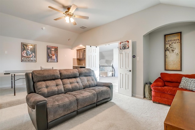 carpeted living room with ceiling fan and vaulted ceiling