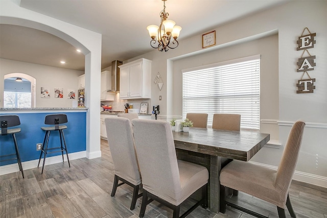 dining space with a notable chandelier and wood-type flooring