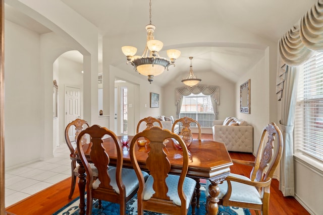 tiled dining space featuring lofted ceiling