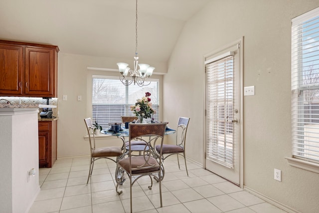 dining space with a chandelier, vaulted ceiling, and light tile patterned floors