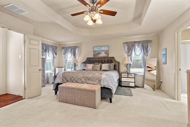 bedroom featuring a tray ceiling, ceiling fan, and carpet flooring