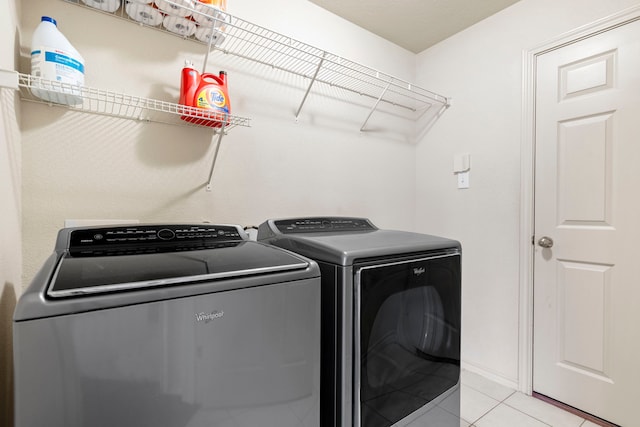 laundry area featuring separate washer and dryer and light tile patterned floors