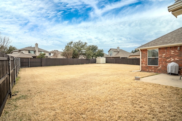 view of yard featuring a storage shed and a patio area