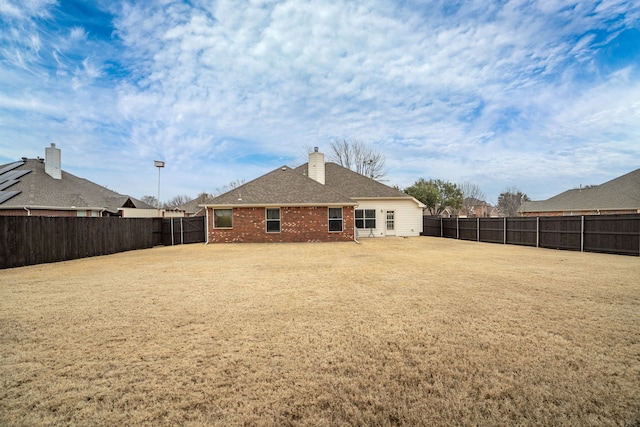 rear view of property with a yard