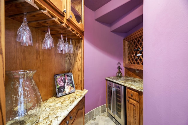 bar with wine cooler and light stone counters