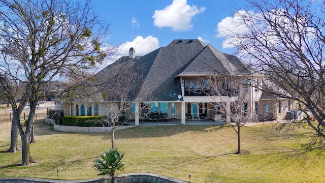 rear view of property featuring a yard, central AC, and a patio