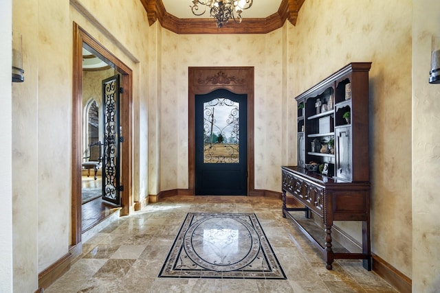 foyer entrance featuring a notable chandelier, ornamental molding, and a high ceiling