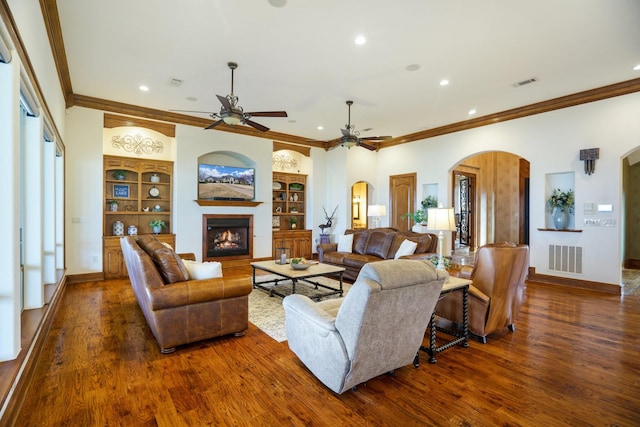 living room with crown molding, dark hardwood / wood-style flooring, and built in features