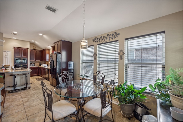 tiled dining room featuring vaulted ceiling