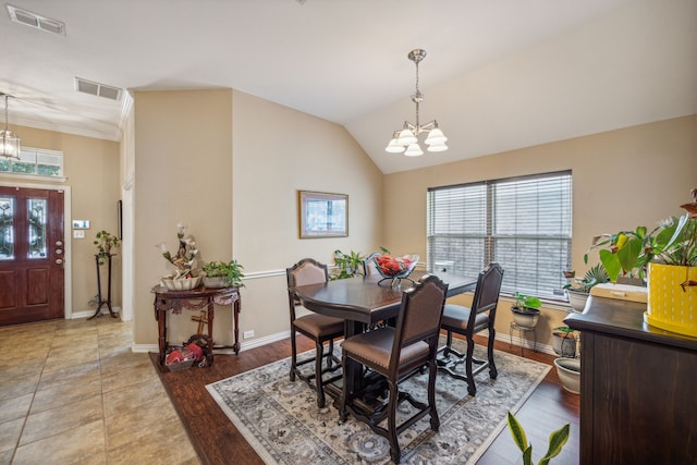 dining room with vaulted ceiling, light wood-type flooring, and an inviting chandelier