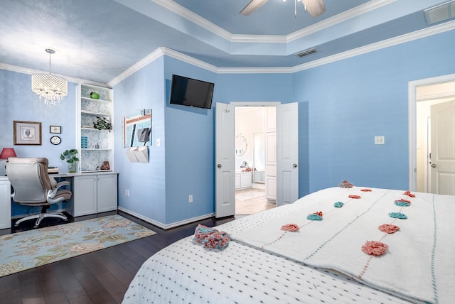 bedroom featuring a raised ceiling, crown molding, dark hardwood / wood-style floors, and connected bathroom