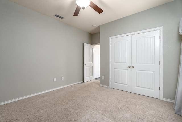 unfurnished bedroom with ceiling fan, a closet, and light carpet