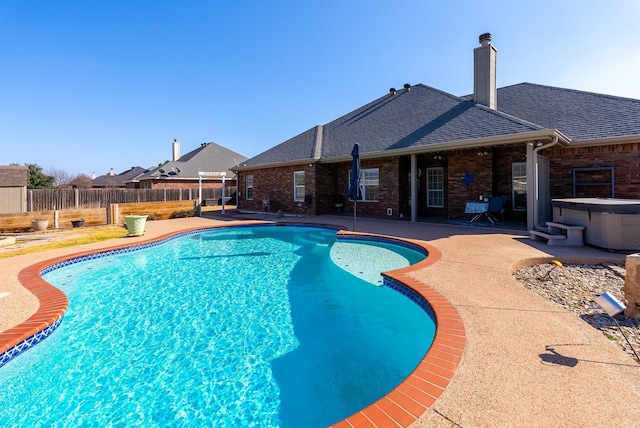 view of swimming pool featuring a hot tub and a patio area