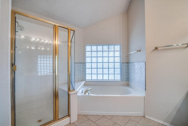 bathroom with vaulted ceiling, separate shower and tub, tile patterned floors, and a textured ceiling