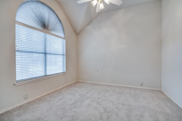 spare room with vaulted ceiling, light colored carpet, and ceiling fan