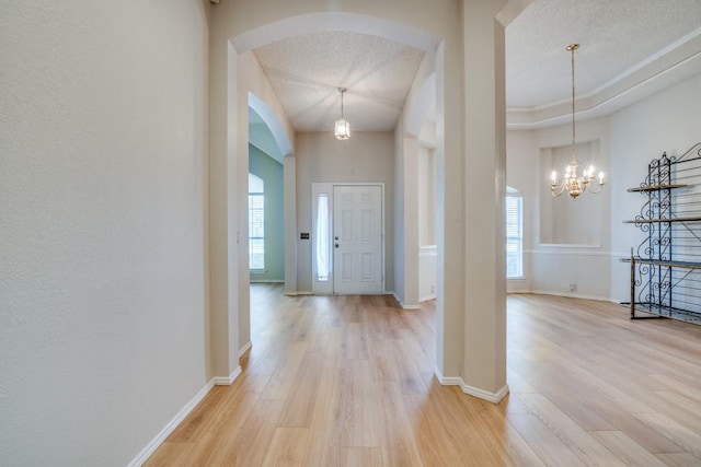 foyer with a chandelier, hardwood / wood-style floors, and a textured ceiling