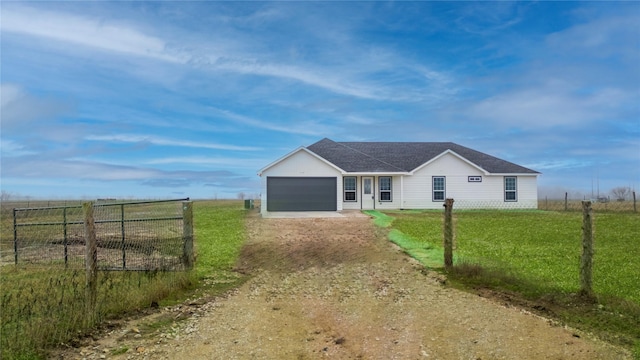 ranch-style home featuring a rural view, a garage, and a front yard