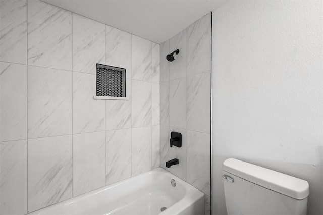 bathroom with toilet and tiled shower / bath combo