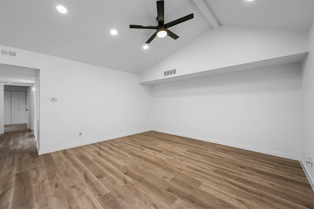 empty room featuring vaulted ceiling with beams, hardwood / wood-style floors, and ceiling fan