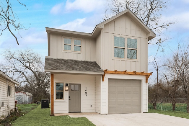 view of front of home featuring a garage, a front yard, and central AC unit