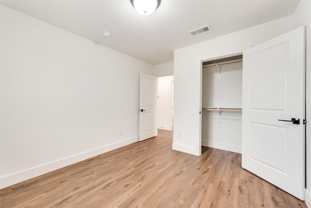 unfurnished bedroom featuring a closet and light hardwood / wood-style flooring