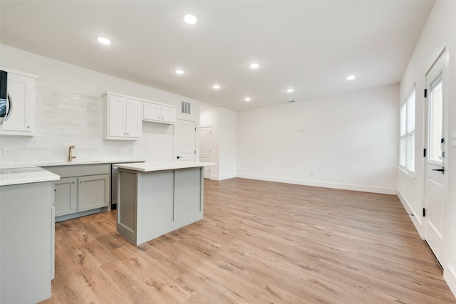 kitchen with a kitchen island, tasteful backsplash, sink, gray cabinetry, and light wood-type flooring