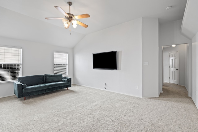 sitting room with vaulted ceiling, light colored carpet, and ceiling fan