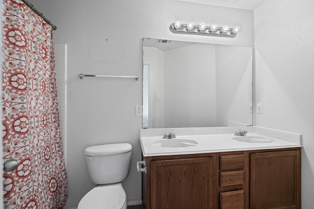 bathroom featuring vanity, curtained shower, and toilet