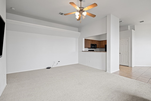 unfurnished living room with ceiling fan, lofted ceiling, and light carpet