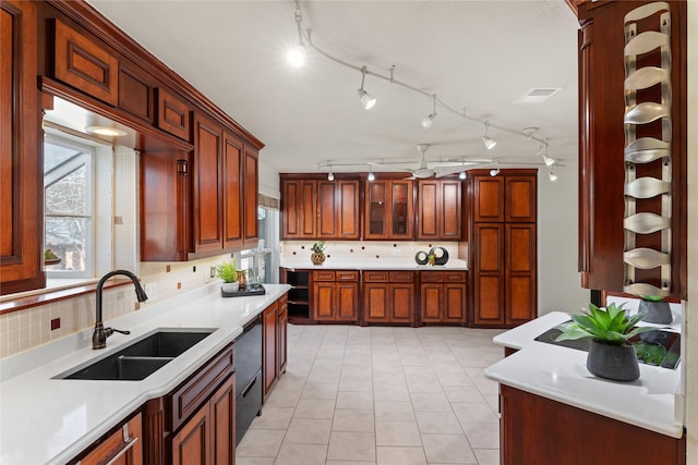 kitchen with tasteful backsplash, dishwasher, sink, and ceiling fan