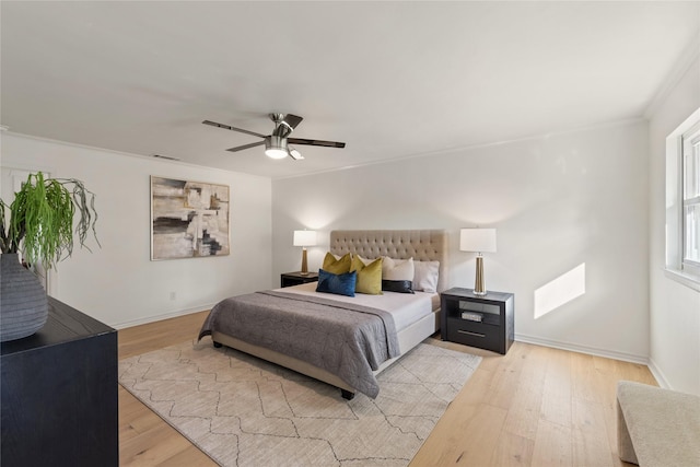 bedroom with light hardwood / wood-style flooring, ornamental molding, and ceiling fan