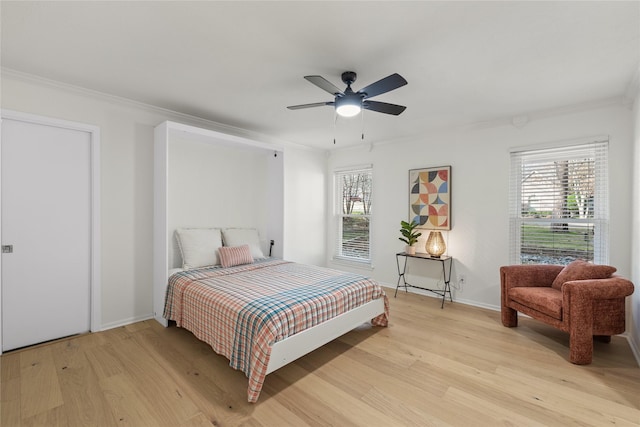 bedroom featuring crown molding, light hardwood / wood-style flooring, and ceiling fan