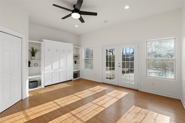 unfurnished living room featuring light hardwood / wood-style flooring, french doors, and ceiling fan