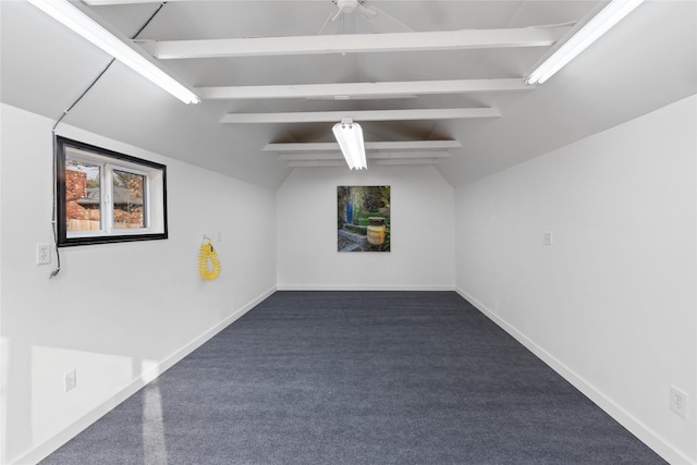 carpeted spare room featuring vaulted ceiling with beams