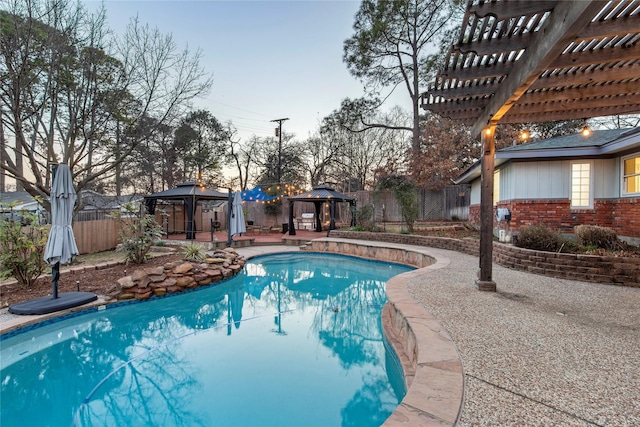 pool at dusk featuring a pergola and a gazebo