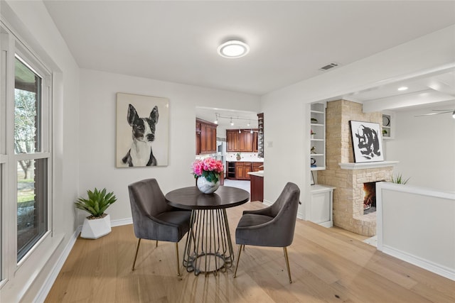 dining space featuring a fireplace and light hardwood / wood-style floors