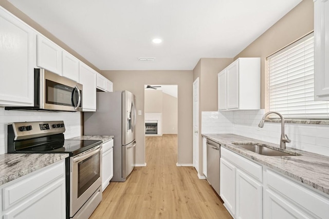 kitchen featuring white cabinetry, appliances with stainless steel finishes, sink, and ceiling fan