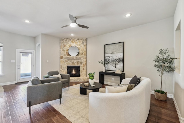 living room with ceiling fan, a fireplace, and dark hardwood / wood-style floors