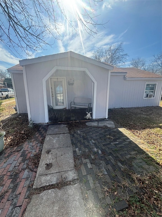 doorway to property with a shingled roof