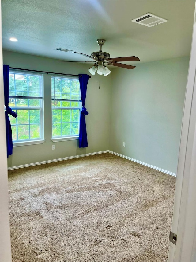 unfurnished room featuring ceiling fan, carpet flooring, and a textured ceiling